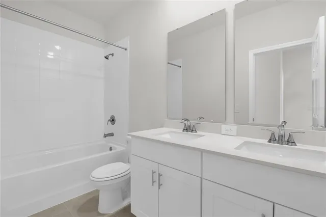 a bathroom with a toilet a sink a mirror a bathtub and vanity