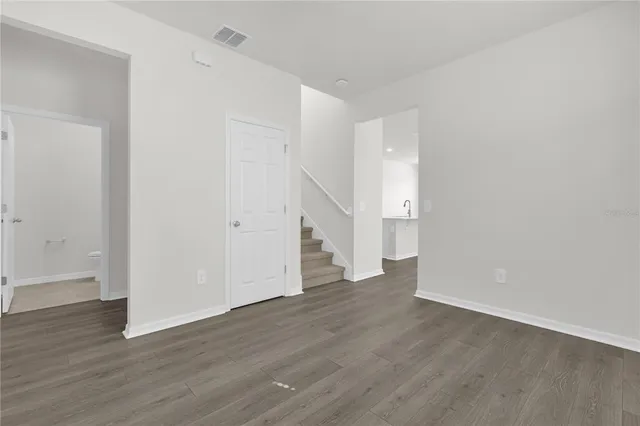 a view of an empty room with wooden floor and entryway