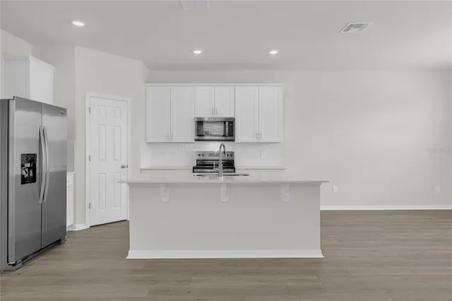 a kitchen with stainless steel appliances granite countertop a stove a sink and a refrigerator