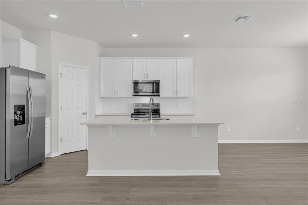 4556 Homestead Trail St. Cloud, FL 34772 - Photo 5 of 31 a kitchen with stainless steel appliances granite countertop a stove a sink and a refrigerator