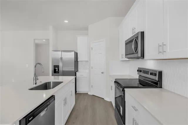 a kitchen with a sink a refrigerator and cabinets