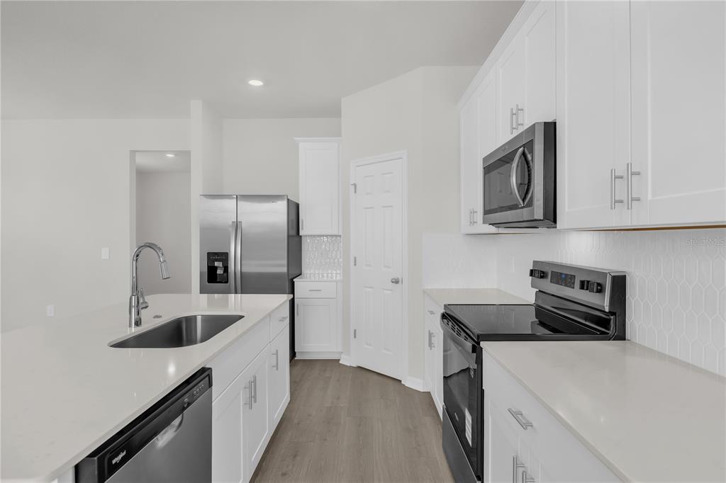 4556 Homestead Trail St. Cloud, FL 34772 - Photo 8 of 31 a kitchen with a sink a refrigerator and cabinets