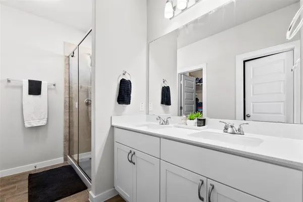 a bathroom with a double vanity sink a mirror and shower