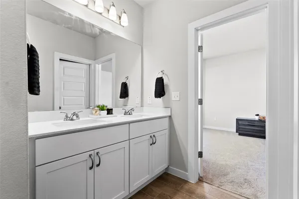 a bathroom with a double vanity sink and mirror