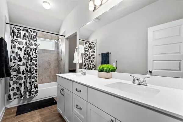 a bathroom with a double vanity sink and a mirror
