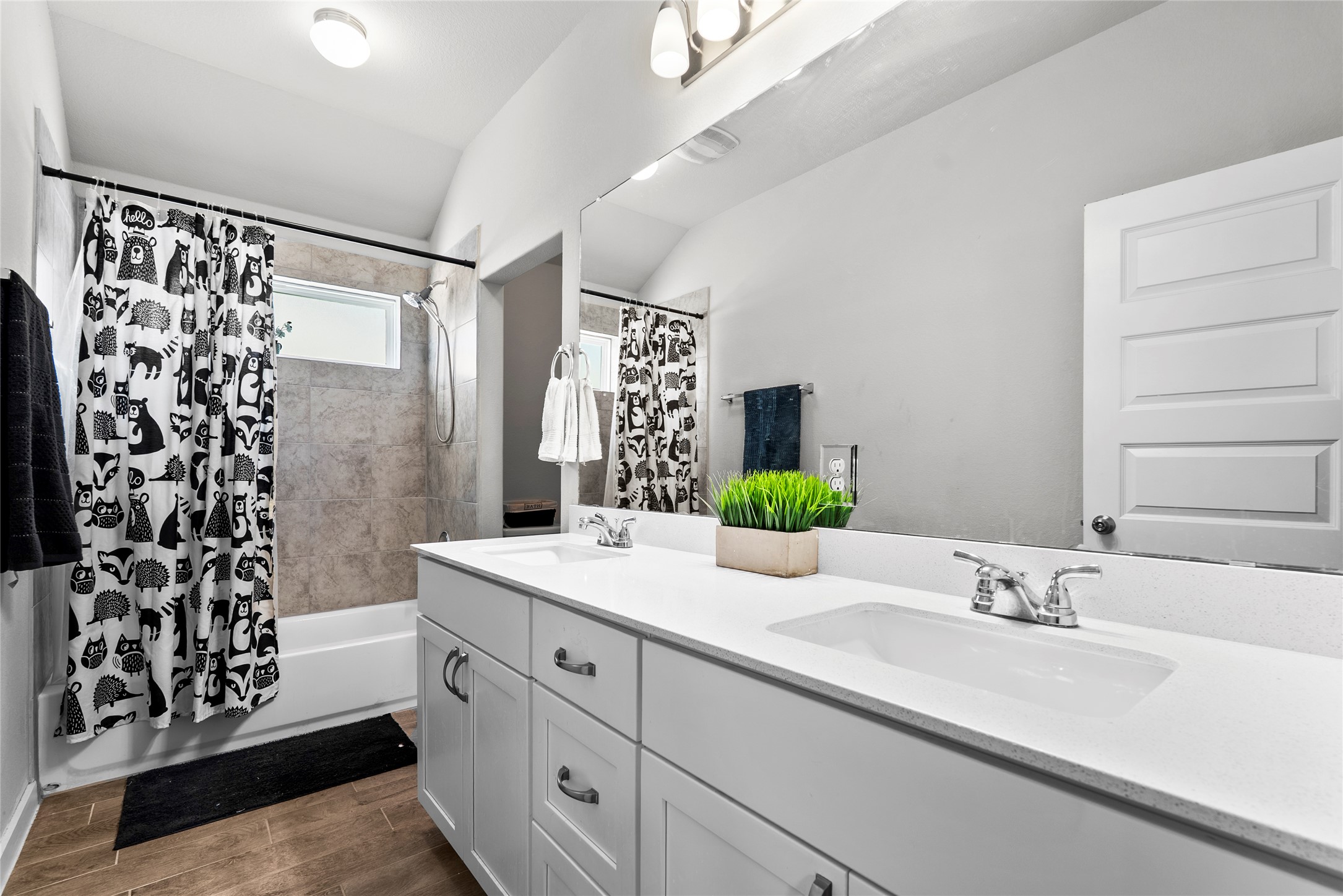 156 Appleberry Lane Elgin, TX 78621 - Photo 22 of 40 Full bathroom featuring shower / bath combo, double vanity, wood tiled floors, and lofted ceiling