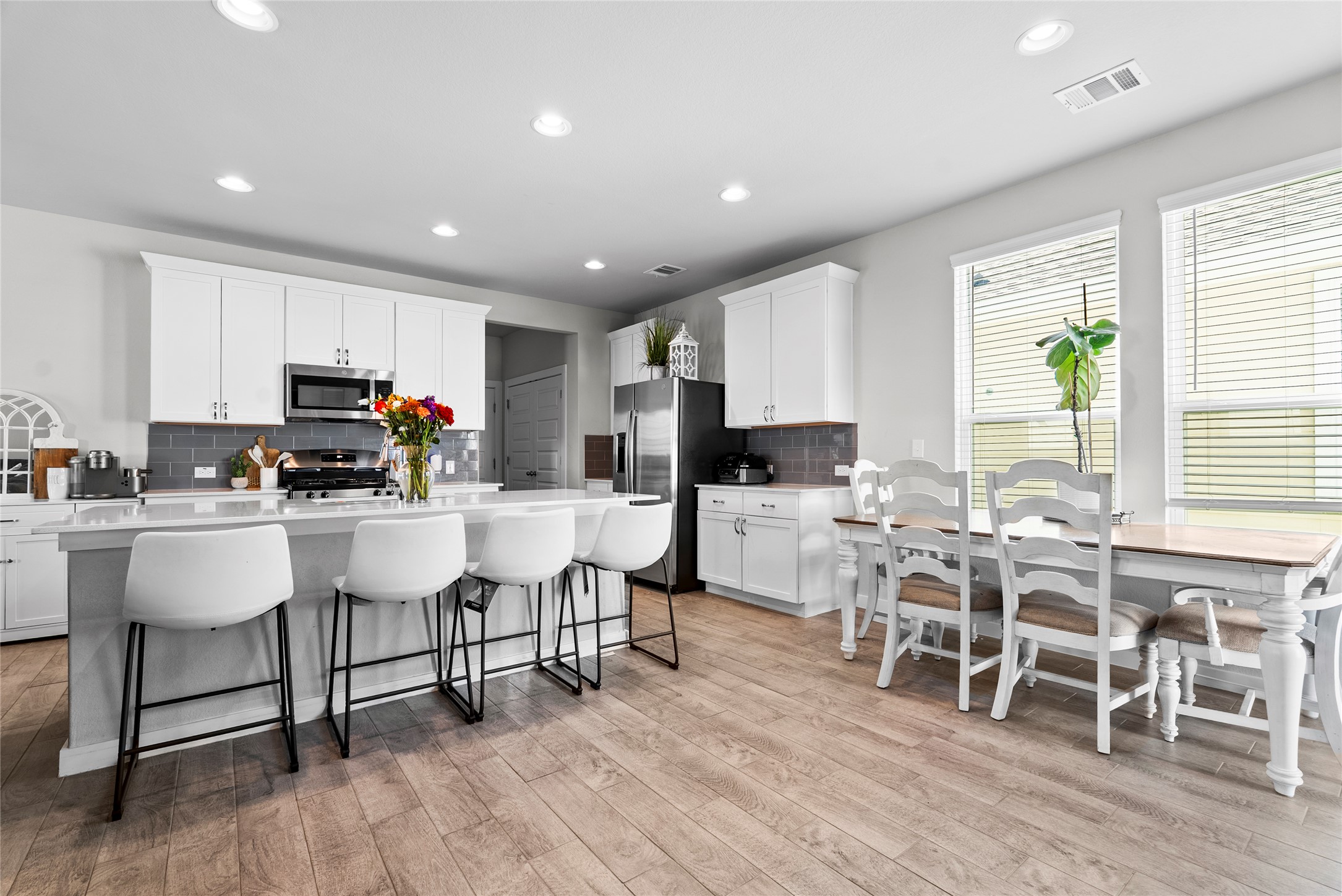 156 Appleberry Lane Elgin, TX 78621 - Photo 4 of 40 The stunning white kitchen is a chef’s dream, with a large island and sleek stainless steel appliances, perfect for both everyday living and entertaining.