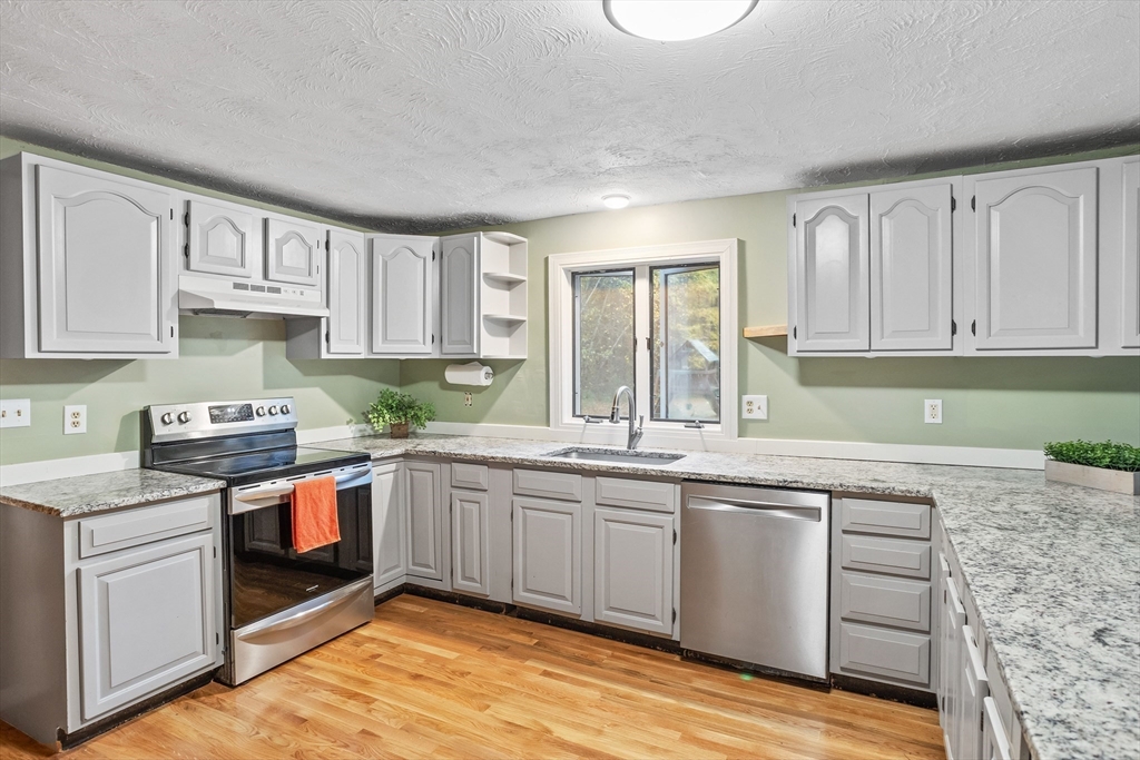 93 Turner Road Townsend, MA 01469 - Photo 12 of 32 a kitchen with stainless steel appliances granite countertop a sink and cabinets with wooden floors