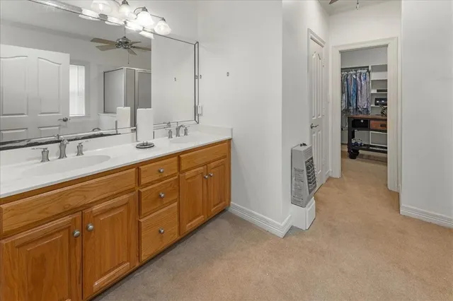 a spacious bathroom with a double vanity sink a mirror and shower