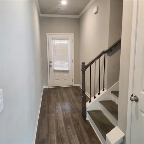 an entryway with wooden floor and staircase