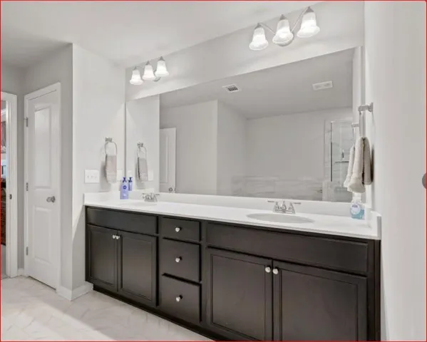 a bathroom with a double vanity sink and a mirror