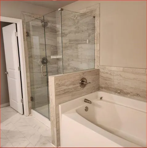 a bathroom with a tub a sink and a shower