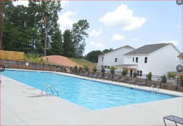 swimming pool view with plants and large trees