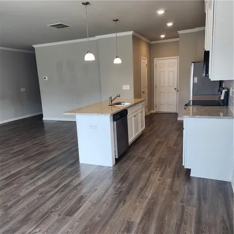 a large kitchen with a sink and a stove top oven