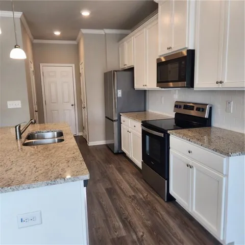 a kitchen with stainless steel appliances granite countertop a stove a sink and a microwave