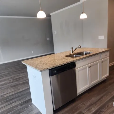 a kitchen with a sink and wooden floor