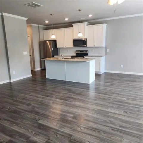 a view of kitchen with stainless steel appliances granite countertop a stove a sink and a refrigerator