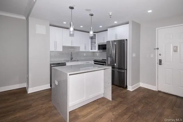 a kitchen that has a refrigerator a stove and a wooden floor
