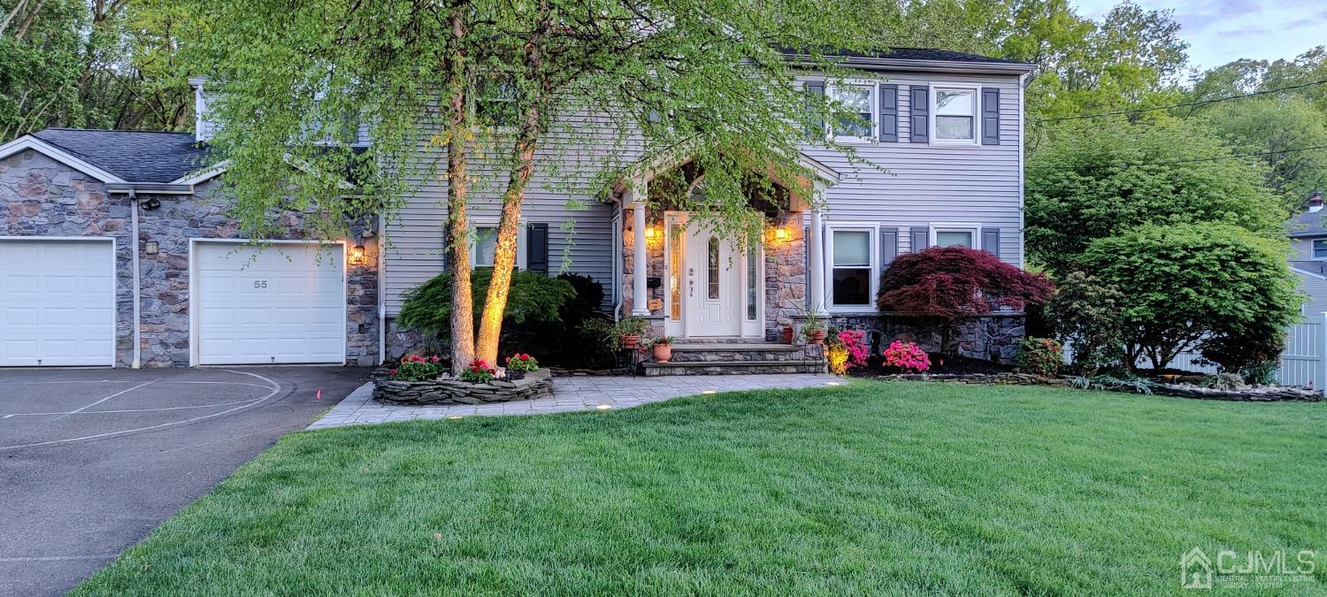 a view of a house with backyard and a tree