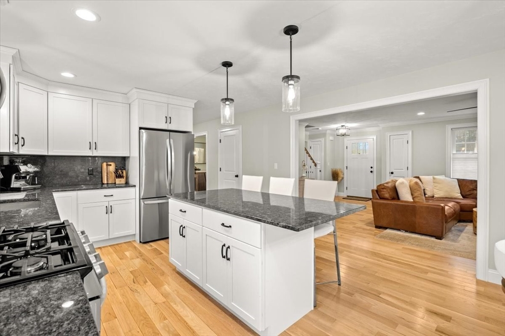 70 Sandy Hill Road Raynham, MA 02767 - Photo 12 of 42 a large white kitchen with stainless steel appliances granite countertop a stove a sink a refrigerator and white cabinets with wooden floor