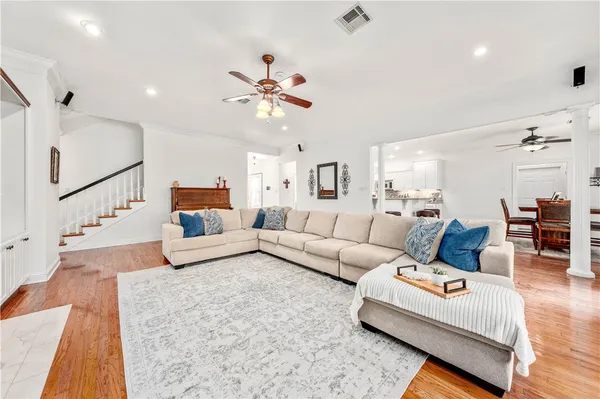 a large living room with stainless steel appliances kitchen island granite countertop furniture and a wooden floor