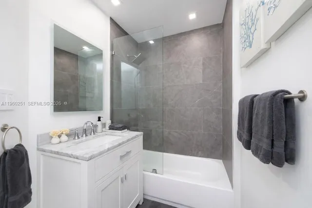 a bathroom with a tub sink and mirror