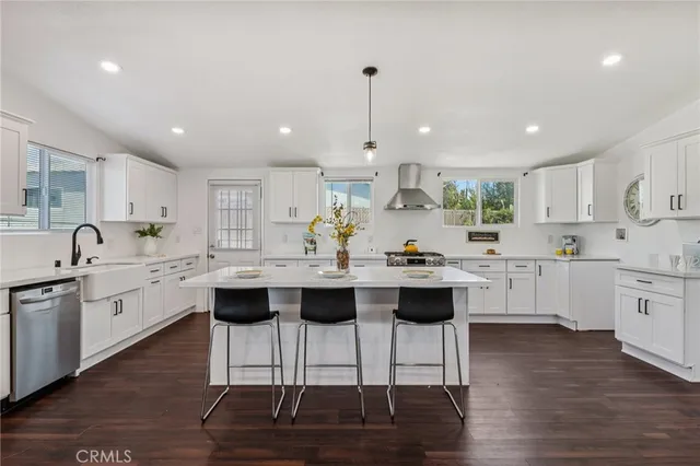 a kitchen with stainless steel appliances kitchen island granite countertop a sink and cabinets