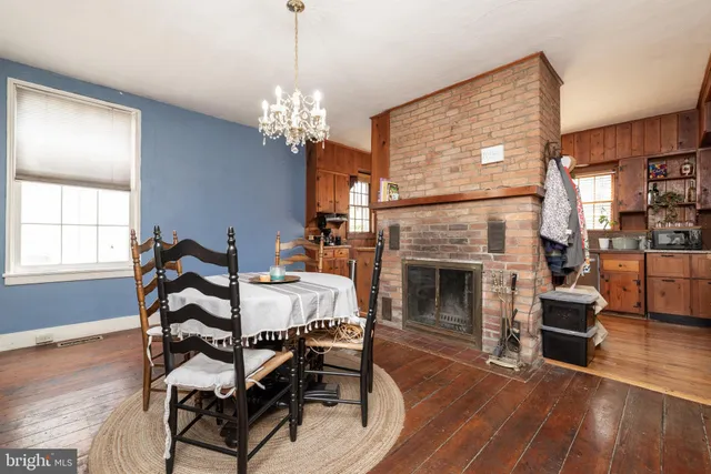 a dining room with furniture a fireplace and wooden floor