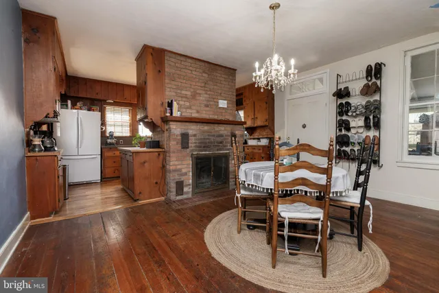 a dining room with furniture a chandelier and wooden floor