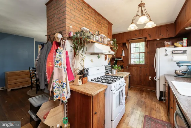 a kitchen that has a lot of cabinets stainless steel appliances and a large window