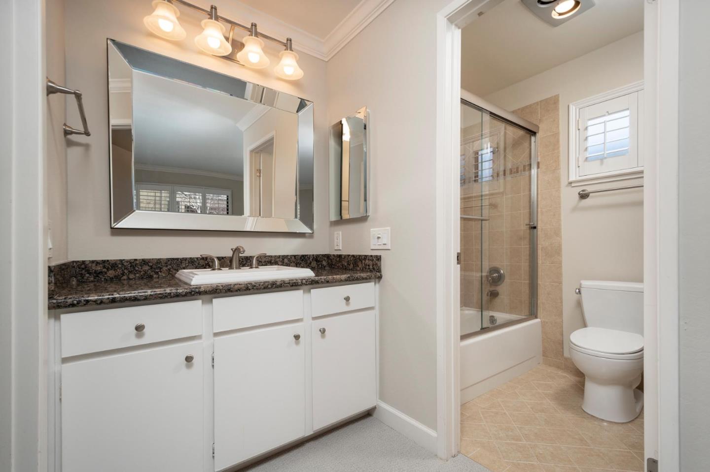 964 Shoreline Drive San Mateo, CA 94404 - Photo 11 of 19 a bathroom with a granite countertop sink a toilet a large mirror and shower