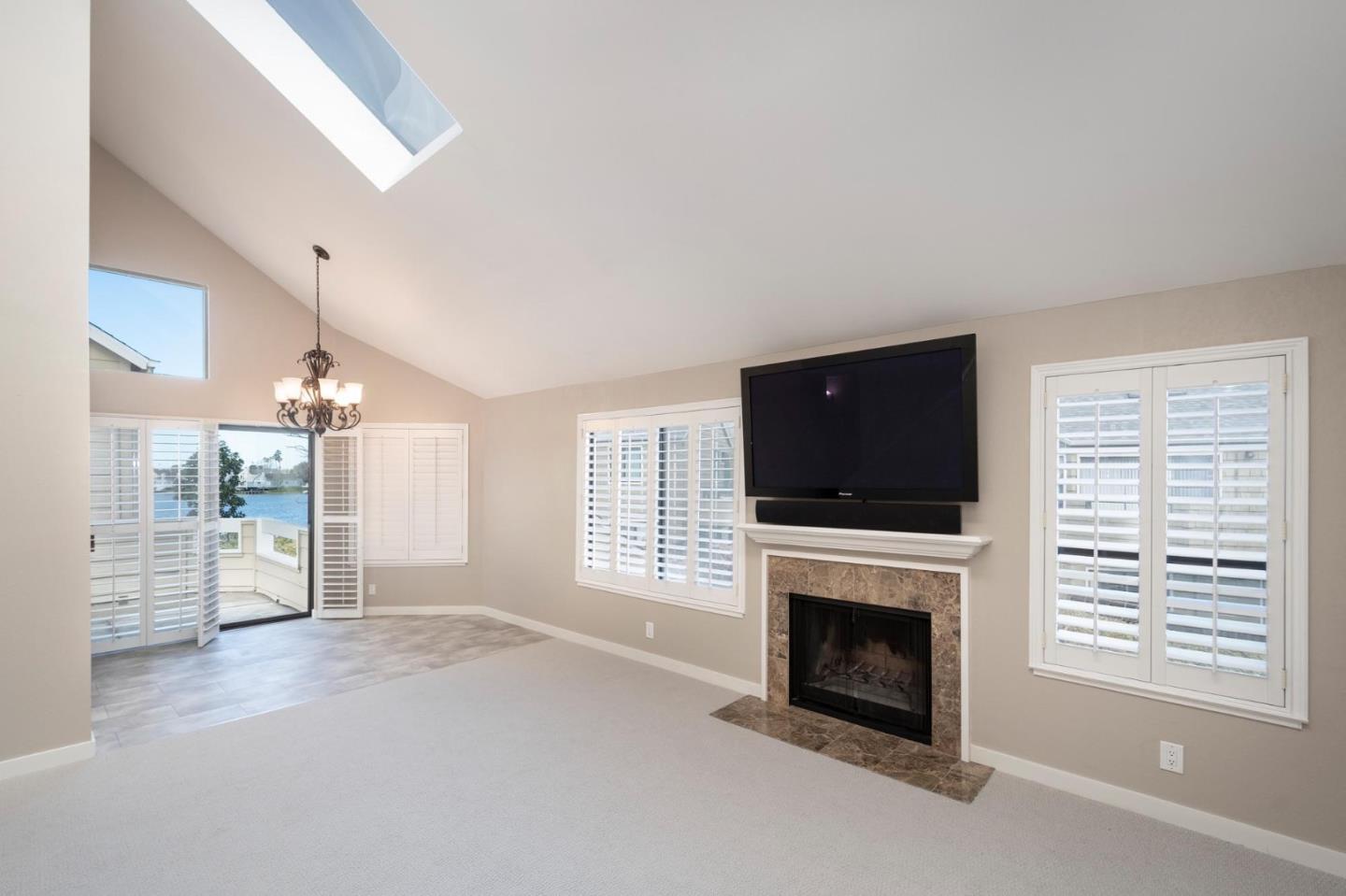 964 Shoreline Drive San Mateo, CA 94404 - Photo 5 of 19 a living room with furniture a flat screen tv and a fireplace