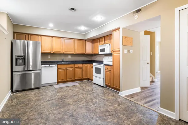 a kitchen with stainless steel appliances granite countertop a refrigerator and a sink
