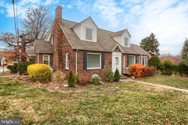 a view of a house with a yard and large tree