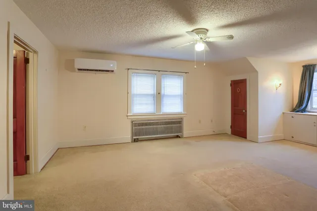 an empty room with fan and windows
