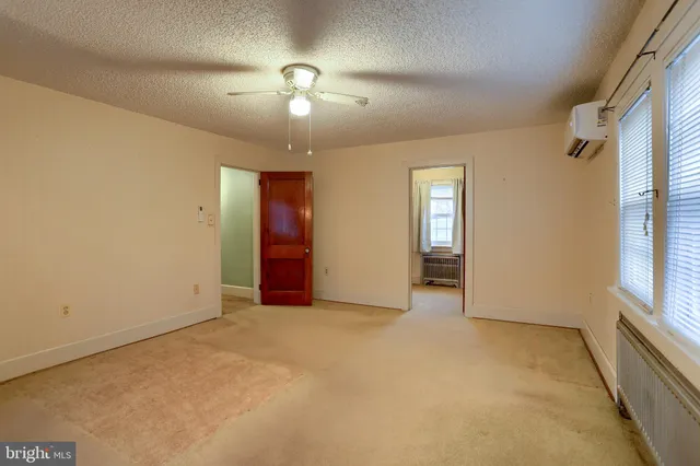 an empty room with windows and cabinet