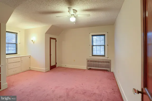an empty room with windows and closet