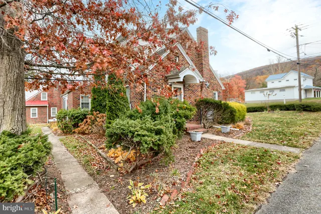a view of a house with a yard and sitting area
