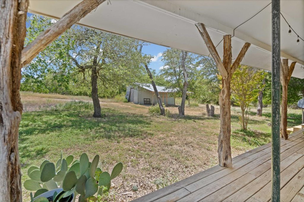 555 Harmon Hills Road, Unit A Dripping Springs, TX 78620 - Photo 26 of 29 A spacious backyard with mature trees and a rustic shed, offering tranquility and natural beauty.