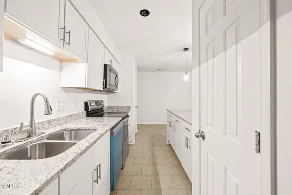a kitchen with stainless steel appliances granite countertop a sink and a refrigerator