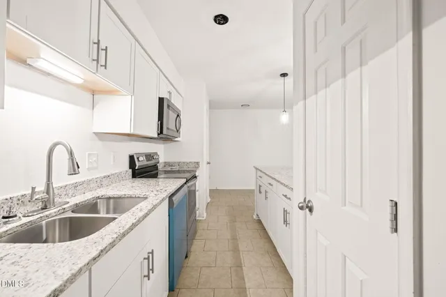 a kitchen with stainless steel appliances granite countertop a sink and a refrigerator