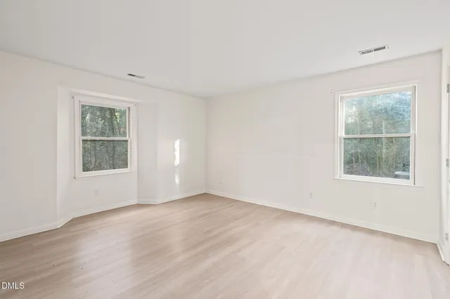an empty room with windows and closet