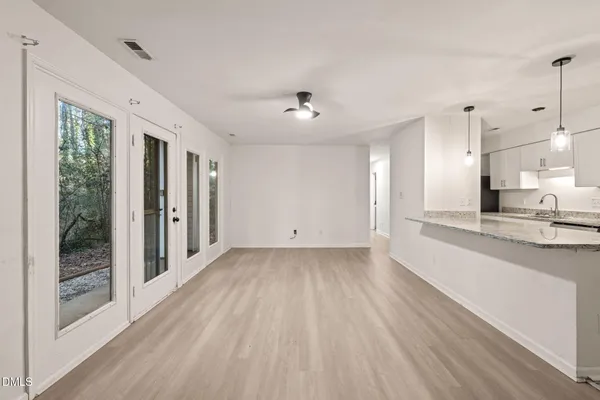 a view of a kitchen with wooden floor and a window