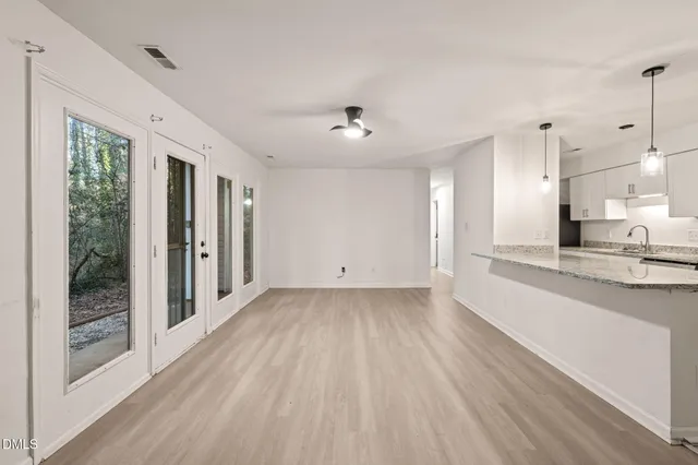 a view of a kitchen with wooden floor and a window
