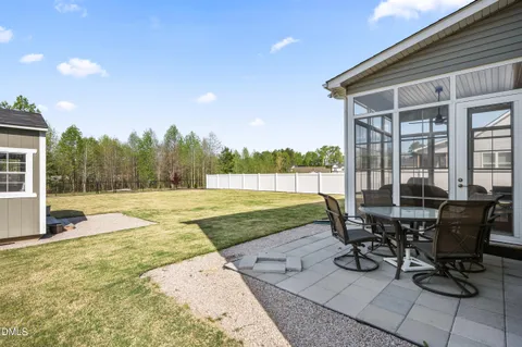 a backyard of a house with table and chairs