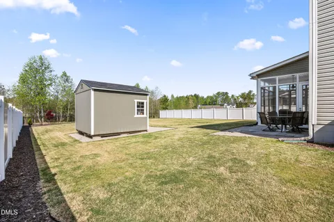 a view of a swimming pool with a patio and a yard