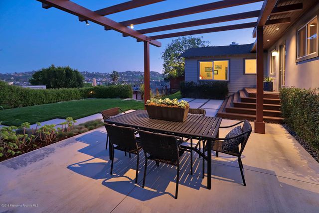 a view of a patio with a dining table and chairs with a garden