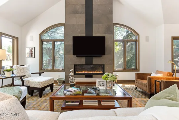 a living room with furniture a large window and a flat screen tv