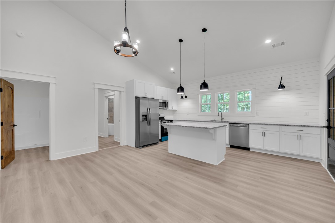 659 White Oak Farms Road Tamassee, SC 29686 - Photo 15 of 50 High vaulted ceilings and wood-look flooring enhance the open kitchen and dining layout.