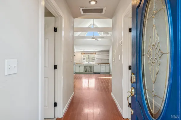 a view of a hallway with wooden floor and staircase